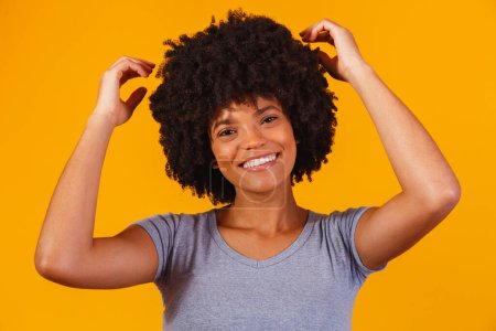 Foto de Hermosa chica afroamericana con un peinado afro sonriendo. Mujer con cabello negro para publicidad de champú - Imagen libre de derechos