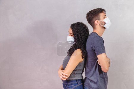 Photo for Profile side view portrait of his he her she offended sick ill unhealthy unwell couple folded arms wearing safety gauze mask mers cov social distance - Royalty Free Image