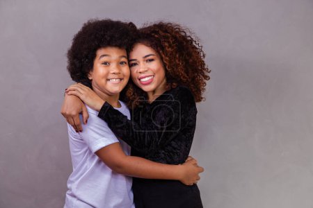 Photo for Portrait of young African American mother with toddler son. Grey background. Brazilian family. - Royalty Free Image
