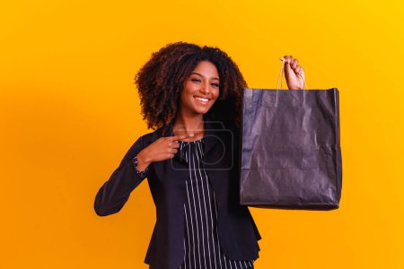 Foto de Mujer afroejecutiva con bolsa negra. Concepto Blackfriday - Imagen libre de derechos