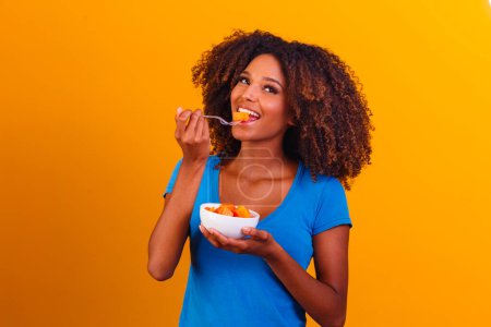 Téléchargez les photos : Afro fille manger de la papaye dans le bol. Concept de saine alimentation - en image libre de droit