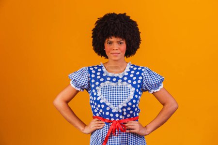 Téléchargez les photos : Femme afro brésilienne portant des vêtements typiques pour la Festa Junina en fond jaune - en image libre de droit