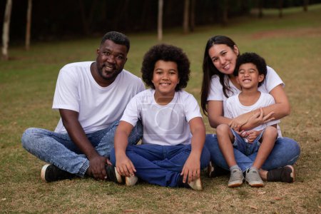Téléchargez les photos : Famille de la diversité avec père afro et mère japonaise. belle famille heureuse dans le parc - en image libre de droit