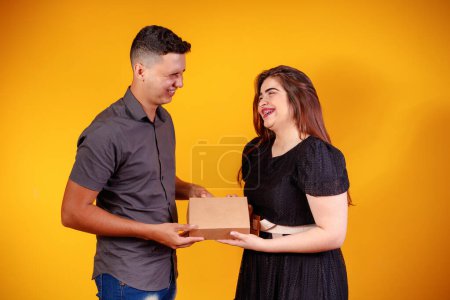 Foto de Joven pareja de San Valentín con caja de dulces haciendo sorpresa. Concepto de regalos y San Valentín. - Imagen libre de derechos