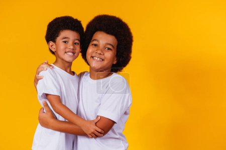 Foto de Hermanos afro sobre fondo amarillo. día del hermano - Imagen libre de derechos