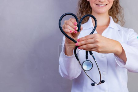 Photo for Photo of nurse holding stethoscope on gray background - Royalty Free Image