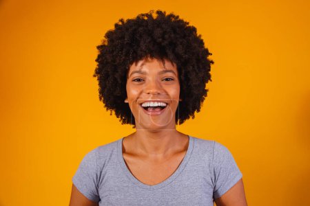 Foto de Hermosa chica afroamericana con un peinado afro sonriendo. Mujer con cabello negro para publicidad de champú - Imagen libre de derechos