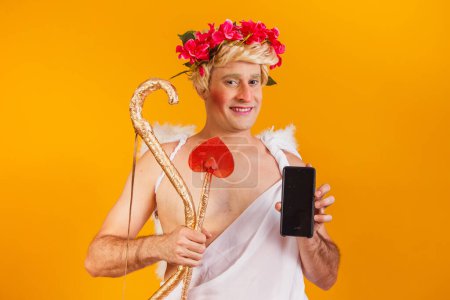 Photo for Cupid holding cell phone. Valentine's Day promotion - Royalty Free Image