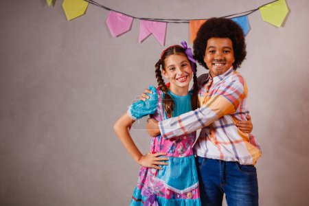 Photo for Children in typical clothes from the famous Brazilian party called "Festa Junina" in celebration of So Joo. Afro boy and white girl celebrating the June party in Brazil - Royalty Free Image