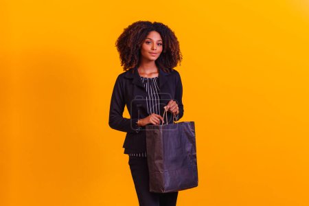 Téléchargez les photos : Femme afro-exécutive avec sac noir. Concept de Blackfriday - en image libre de droit