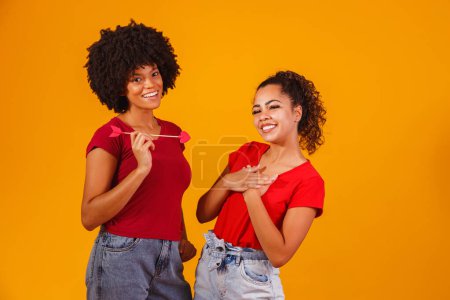Foto de Afro pareja lesbiana sobre fondo amarillo. pareja homosexual-afectiva - Imagen libre de derechos