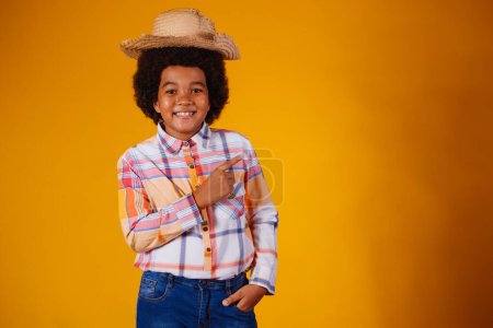 Téléchargez les photos : Portrait d'un petit garçon afro vêtu de vêtements typiques pour la Festa Junina - en image libre de droit