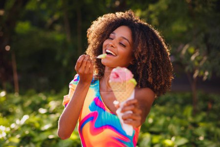 Photo for Happy afro woman eating ice cream in the park. - Royalty Free Image