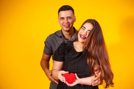 Téléchargez les photos : Jeune couple de valentin tenant un chocolat en forme de cœur. couple tenant un cœur - en image libre de droit