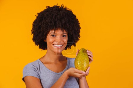 Téléchargez les photos : Jeune belle femme tenant papaye sur fond jaune isolé - en image libre de droit