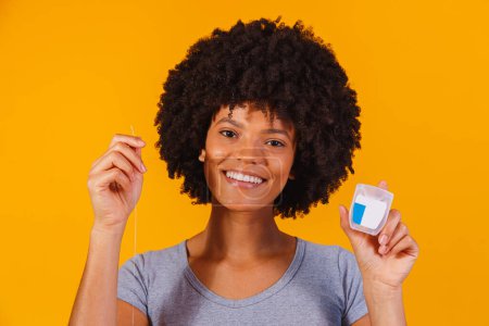 Photo for Afro woman flossing her teeth. oral health concept - Royalty Free Image