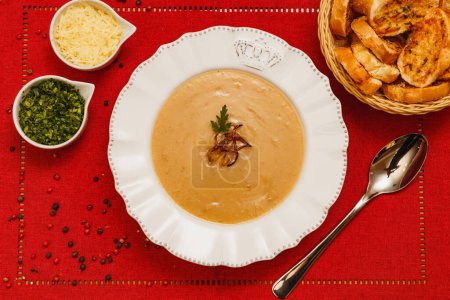 Delicious bean broth, Bean soup, with wooden background, red fabric background, with toast, parsley and parmesan, Brazilian winter foods, gourmet cuisine