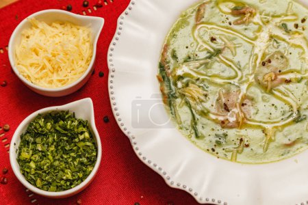 Téléchargez les photos : Délicieux bouillon de brocoli vert, soupe de brocoli vert, végétarien, au parmesan râpé et au persil, avec fond en bois et tissu rouge, Gastronomie, Aliments d'hiver brésiliens - en image libre de droit