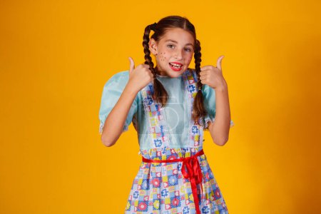Foto de Niño en ropa típica de la famosa fiesta brasileña llamada "Festa Junina" en celebración de So Joo. Hermosa chica sobre fondo amarillo
. - Imagen libre de derechos