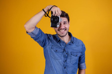 Photo for Cute photographer on yellow background. man with a photo camera - Royalty Free Image