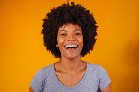 Téléchargez les photos : Belle afro-américaine avec une coiffure afro souriante. Femme avec des cheveux noirs de puissance pour la publicité de shampooing - en image libre de droit