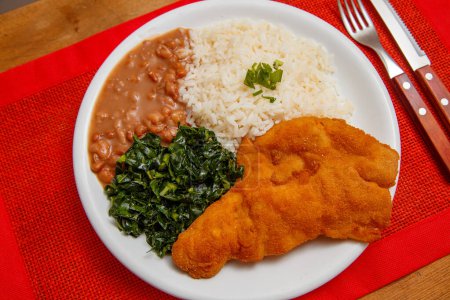 Photo for Delicious breaded chicken dish with rice, beans and cabbage - Royalty Free Image