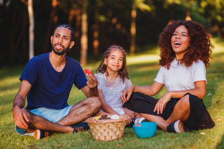 Téléchargez les photos : Bonne famille faisant un pique-nique dans le parc - en image libre de droit