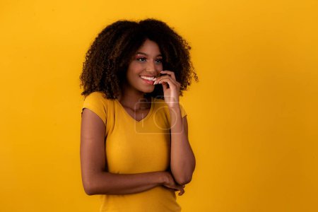 Téléchargez les photos : Femme afro nerveuse sur fond jaune - en image libre de droit