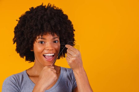 Téléchargez les photos : Afro femme soie dentaire. concept de santé buccodentaire - en image libre de droit