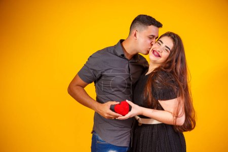 Téléchargez les photos : Jeune couple de valentin tenant un chocolat en forme de cœur. couple tenant un cœur - en image libre de droit