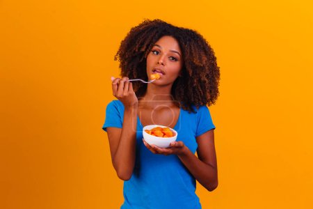 Téléchargez les photos : Afro fille manger de la papaye dans le bol. Concept de saine alimentation - en image libre de droit