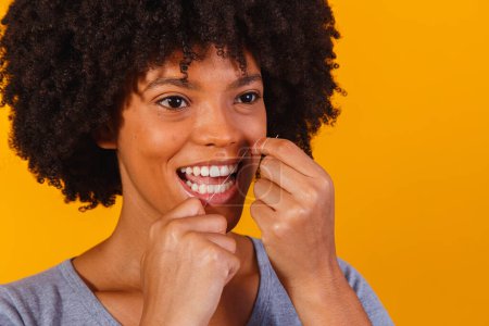 Téléchargez les photos : Afro femme soie dentaire. concept de santé buccodentaire - en image libre de droit