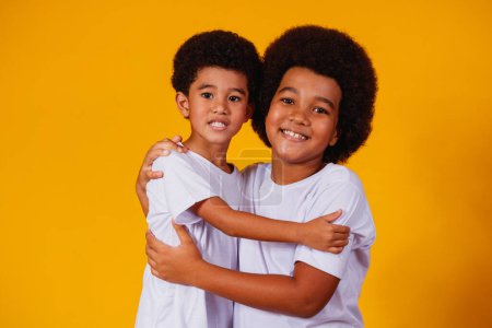 Téléchargez les photos : Frères afro sur fond jaune. jour du frère - en image libre de droit
