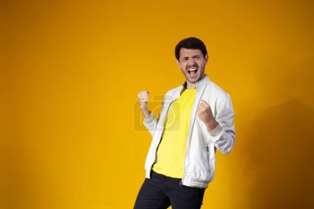 Photo for Brazilian soccer player celebrates isolated on yellow  background - Royalty Free Image