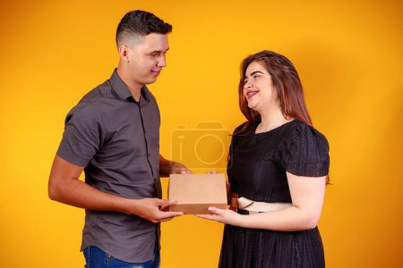 Foto de Joven pareja de San Valentín con caja de dulces haciendo sorpresa. Concepto de regalos y San Valentín. - Imagen libre de derechos