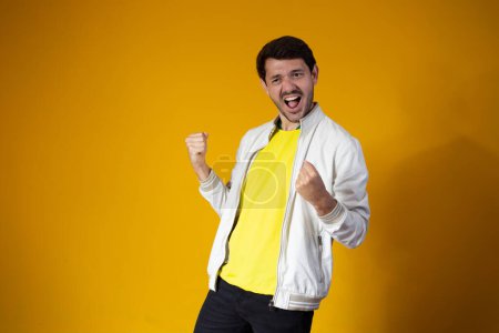 Photo for Brazilian soccer player celebrates isolated on yellow  background - Royalty Free Image