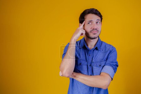 Photo for Thoughtful man on yellow background with space for text. - Royalty Free Image