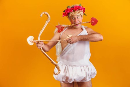 Photo for Valentine's day concept. Portrait of the God of love - Cupid with bow and arrow on a yellow background. - Royalty Free Image