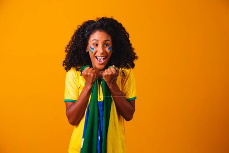 Foto de Abanico brasileño. Abanico brasileño celebrando partido de fútbol o fútbol sobre fondo amarillo. Colores de Brasil. - Imagen libre de derechos