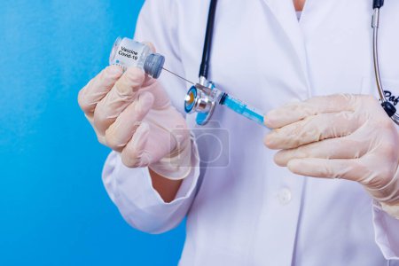 Photo for Nurse holding covid 19 vaccine and syringe. Coronavac. Vaccination against the new Corona Virus Vacine-Covid19: A syringe being drawn up with Vacine-Covid 19. - Royalty Free Image