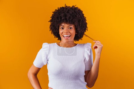 Téléchargez les photos : Portrait de beauté de femme afro-américaine avec coiffure afro et maquillage glamour. Une Brésilienne. Mixte. Cheveux bouclés. Coiffure. Fond jaune - en image libre de droit
