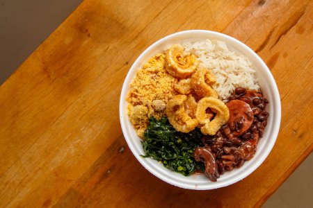 Photo for Feijoada, the Brazilian cuisine tradition.Delicious dish made of feijoada with crackling - Royalty Free Image