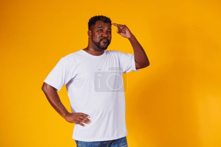 Foto de Afro hombre olvidado y confundido sobre fondo amarillo - Imagen libre de derechos