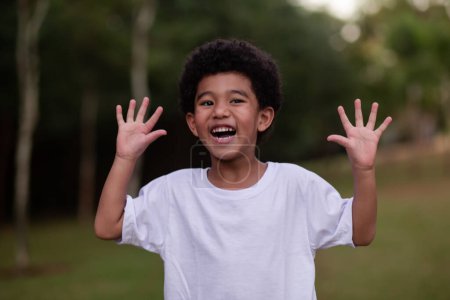 Photo for Little afro boy grimacing showing hands to camera - Royalty Free Image
