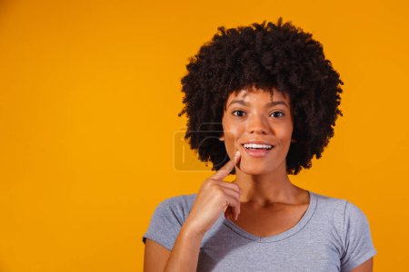 Photo for Afro woman thinking on yellow background with space for text - Royalty Free Image