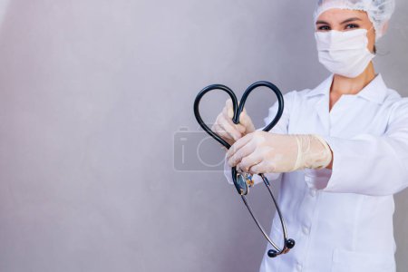 Foto de Foto de la enfermera sosteniendo estetoscopio sobre fondo gris - Imagen libre de derechos