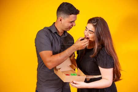 Photo for Young valentine couple with candy box making surprise. Gifts and valentines concept. - Royalty Free Image
