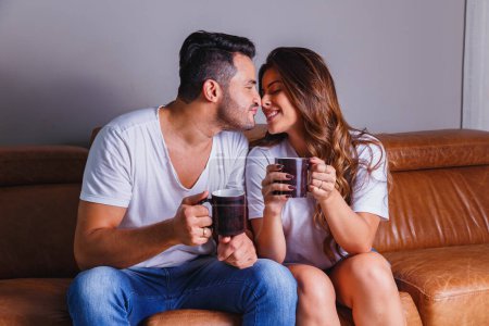 Photo for Valentine couple drinking tea or hot chocolate on the sofa - Royalty Free Image