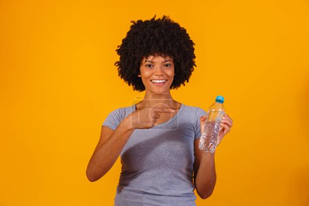 Téléchargez les photos : Afro femme avec bouteille d'eau - en image libre de droit