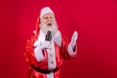 Photo for Santa Claus singing or speaking in a studio microphone. Merry Christmas. Broadcaster. Announcer. Promotion. Christmas music concept - Royalty Free Image